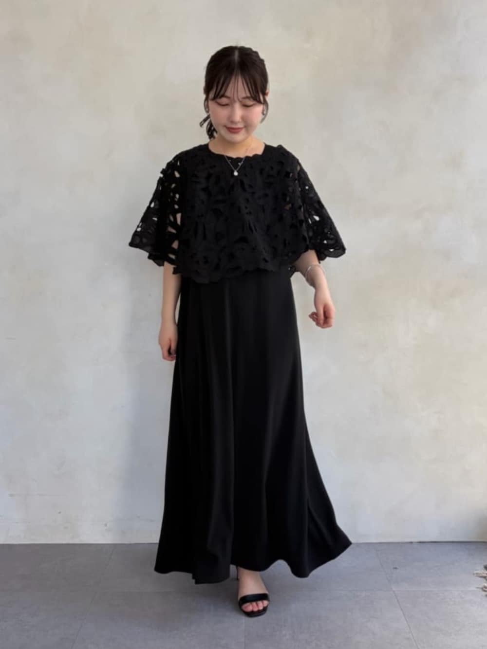 グレー系のハンドバッグ、ブラック系のワンピース、ブラック系のシャツ/ブラウスを着用したレディースの春コーディネートの2枚目の写真