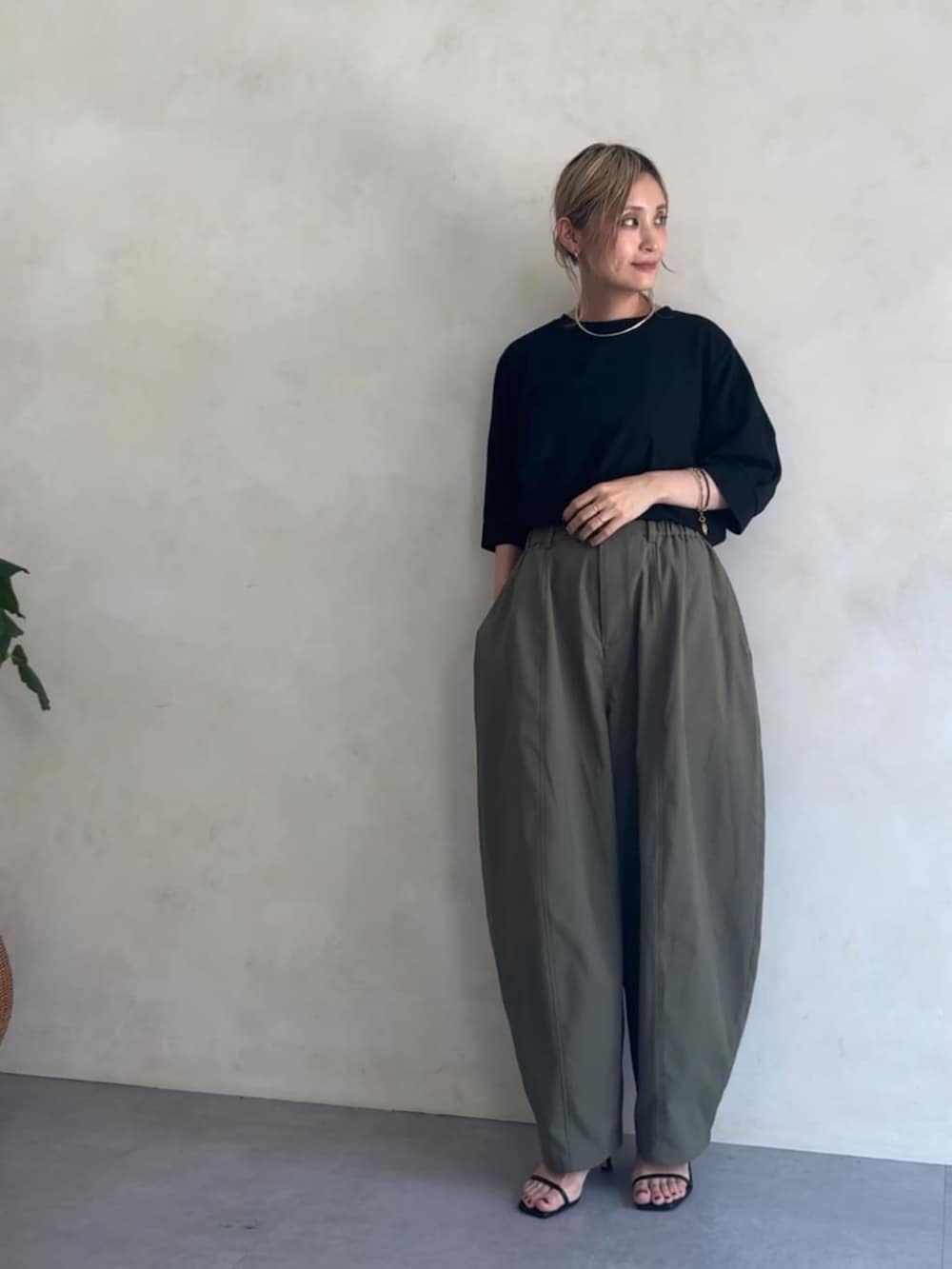 グリーン系のその他パンツ、ブラック系のTシャツ/カットソーを着用したレディースの夏コーディネートの2枚目の写真