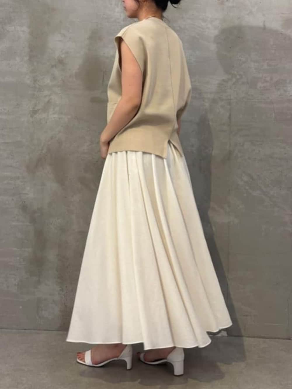 ホワイト系のスカート、ベージュ系のカーディガン/ボレロを着用したレディースの春コーディネートの3枚目の写真