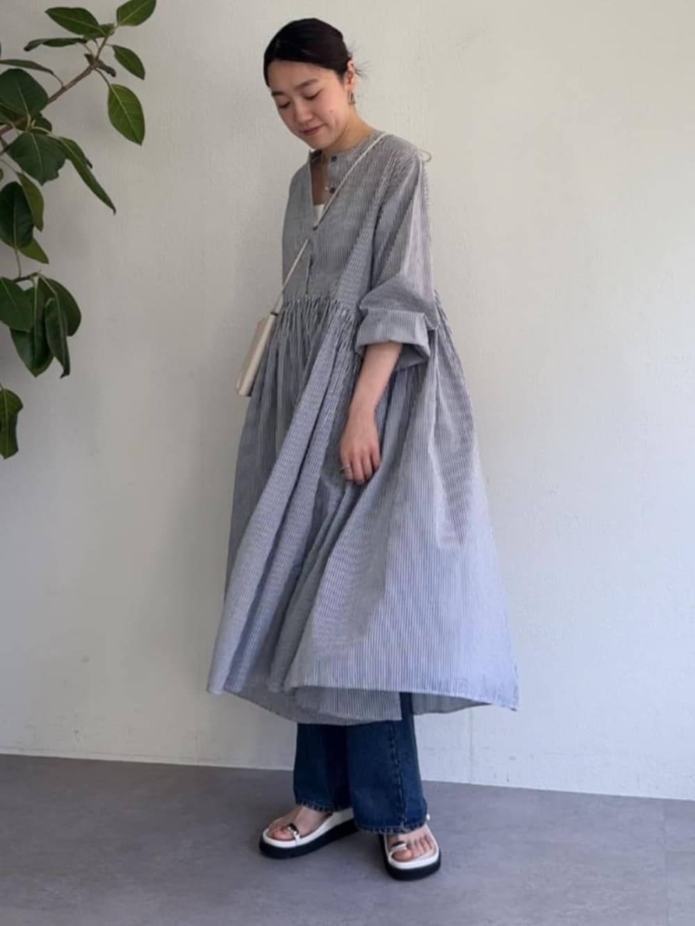 ホワイト系のショルダーバッグ、ブルー系のワンピースを着用したレディースの冬コーディネートの4枚目の写真