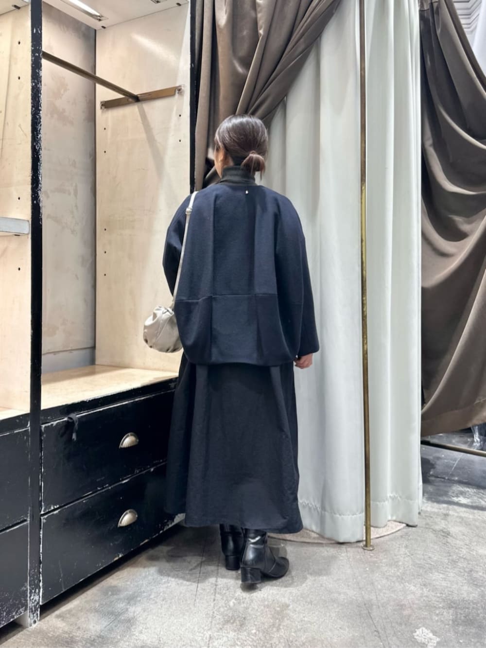 グレー系のワンピース、ブルー系のノーカラーコートを着用したレディースの冬コーディネートの3枚目の写真