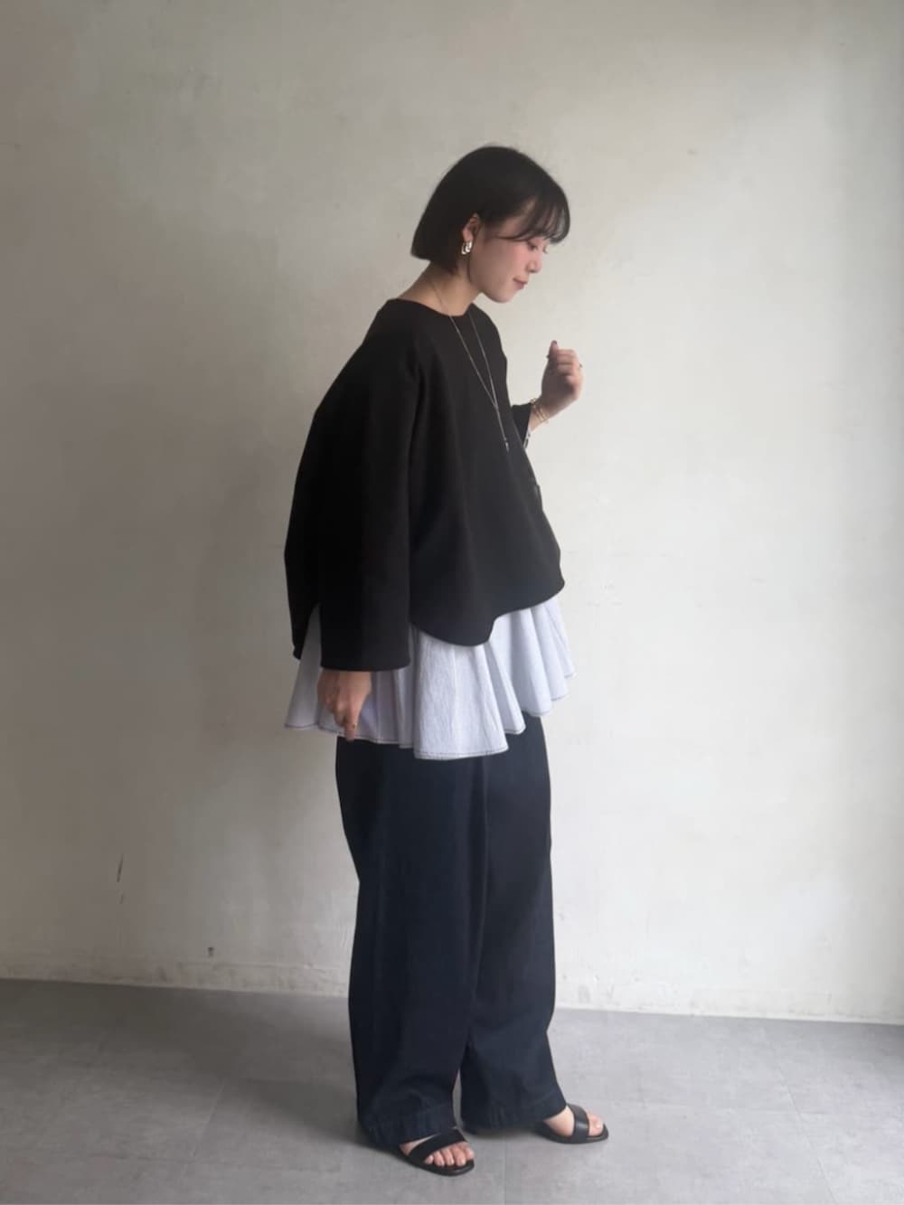 ブラック系のボストンバッグ、ブラック系のTシャツ/カットソー、ブルー系のデニムパンツを着用したレディースの冬コーディネートの3枚目の写真