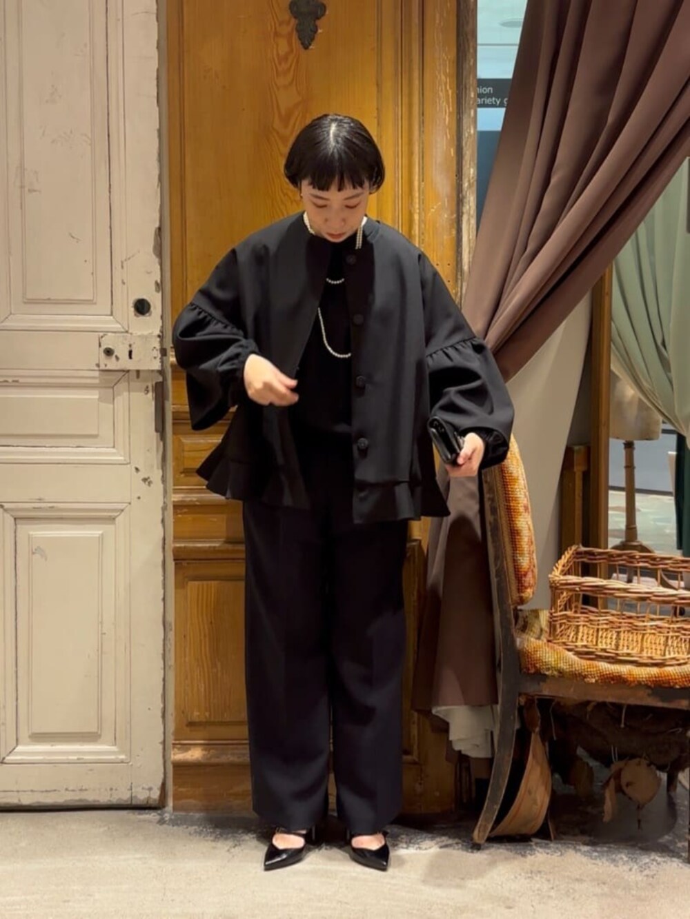 グリーン系のハンドバッグ、ブラック系のその他アウター、ブラック系のその他パンツを着用したレディースの冬コーディネートの5枚目の写真