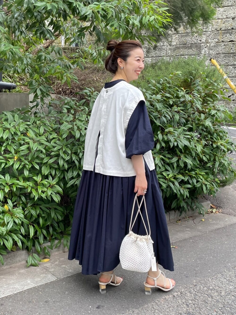 ホワイト系のベスト、ブルー系のワンピースを着用したレディースの夏コーディネートの3枚目の写真