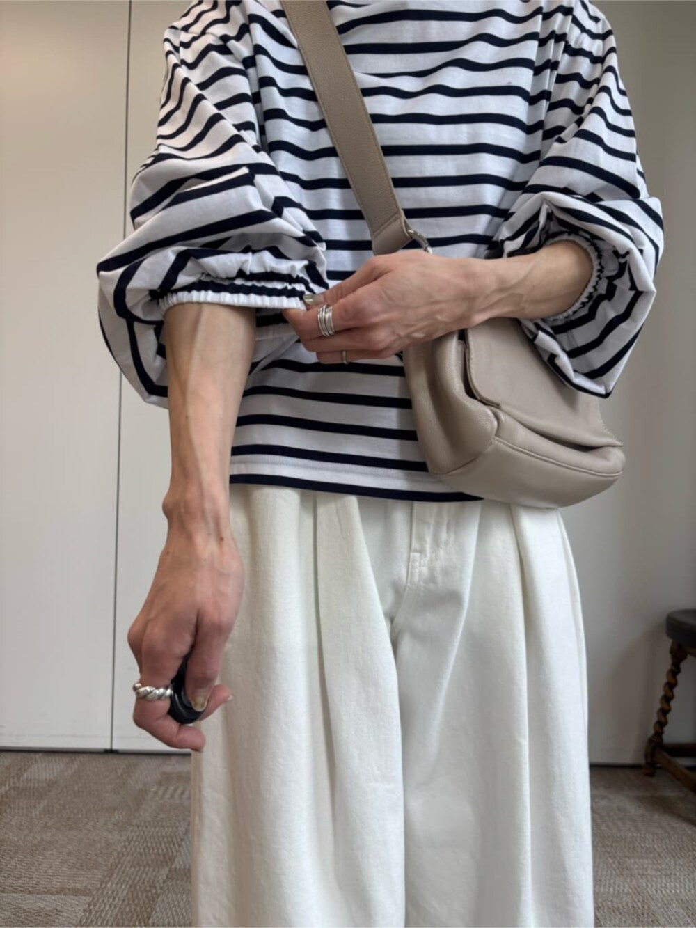 ベージュ系のショルダーバッグ、ホワイト系のTシャツ/カットソーを着用したレディースの冬コーディネートの6枚目の写真