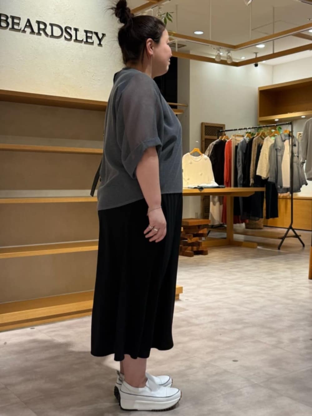 ホワイト系のスニーカー、ブラック系のワンピース、グレー系のTシャツ/カットソーを着用したレディースの夏コーディネートの3枚目の写真
