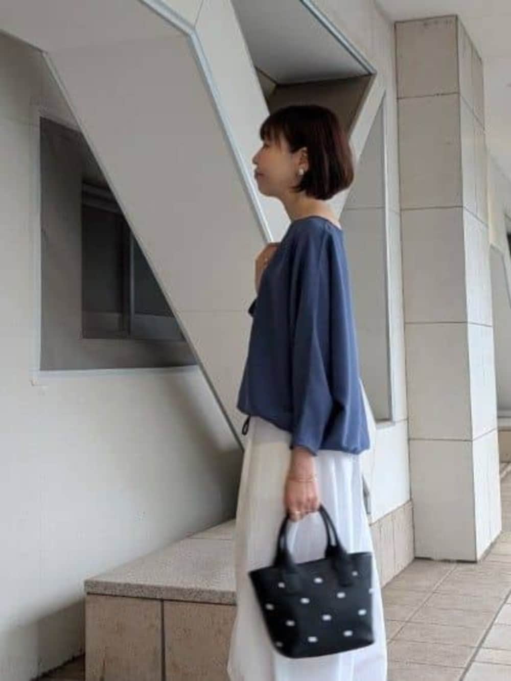 ブラック系のトートバッグ、ブルー系のシャツ/ブラウス、ホワイト系のその他パンツを着用したレディースの冬コーディネートの4枚目の写真