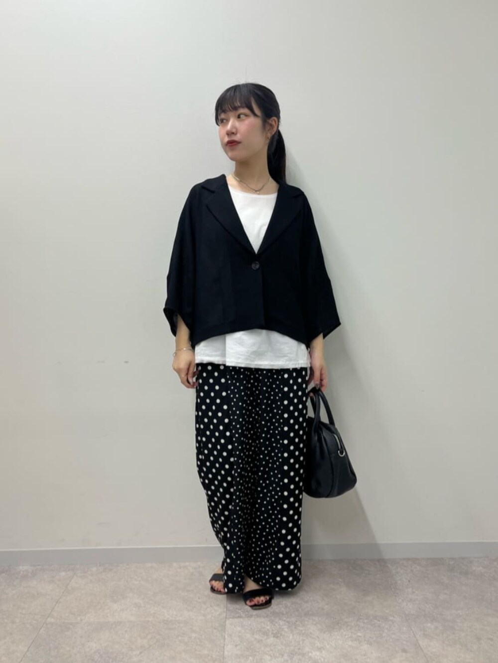 ブラック系のボストンバッグ、ホワイト系のシャツ/ブラウス、ブラック系のその他パンツを着用したレディースの春コーディネートの2枚目の写真
