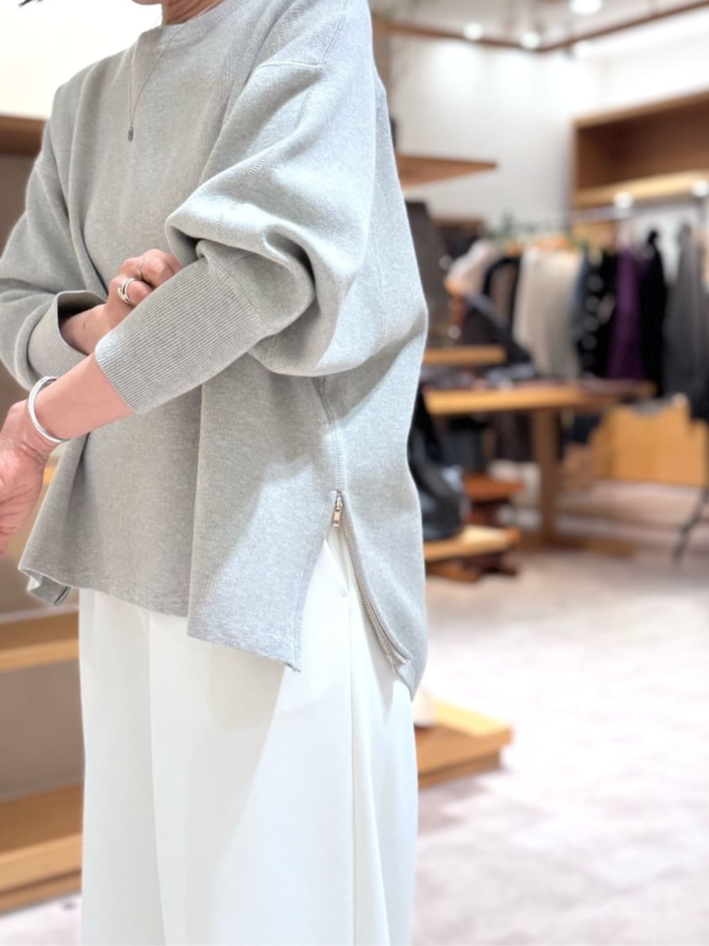 ホワイト系のその他パンツ、ブルー系のハンドバッグ、グレー系のニット/セーターを着用したレディースの冬コーディネートの9枚目の写真