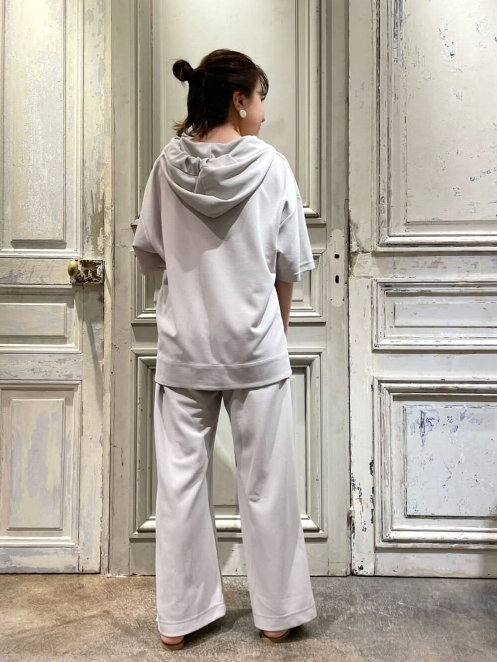 グレー系のパーカー、グレー系のその他パンツ、ホワイト系のサンダルを着用したレディースの夏コーディネートの3枚目の写真