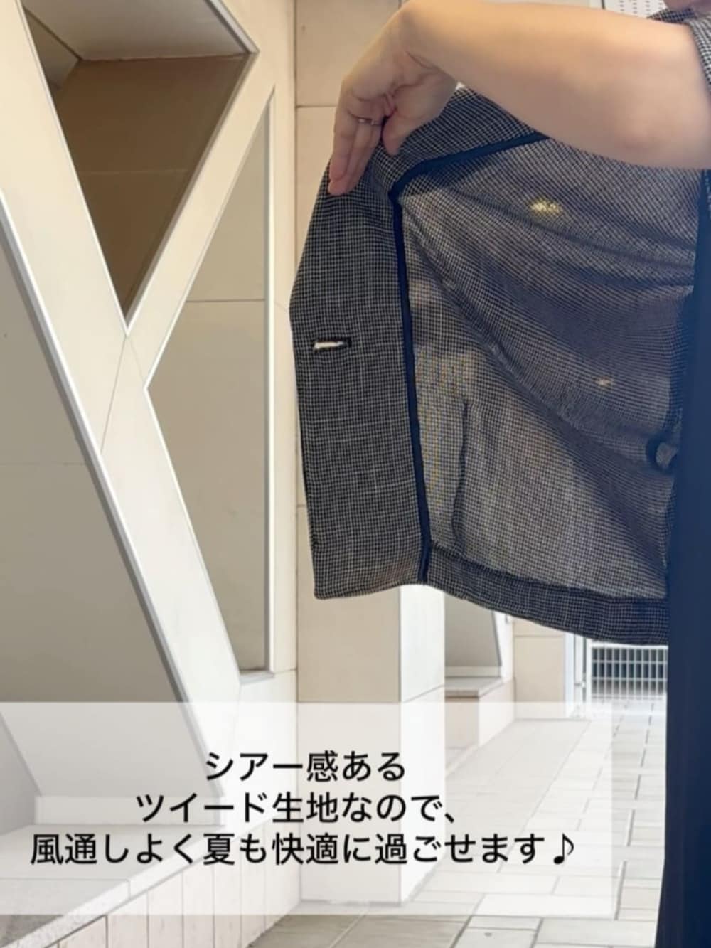 ベージュ系のテーラードジャケット、ブラック系のワンピース、ブラック系のスニーカーを着用したレディースの夏コーディネートの6枚目の写真