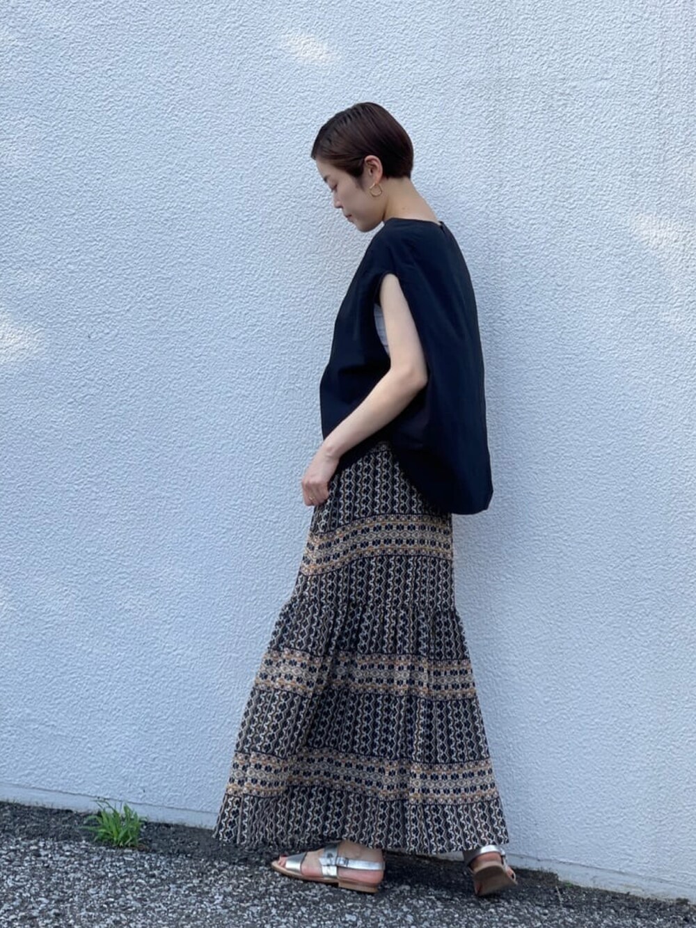 ブラック系のシャツ/ブラウス、ブラック系のスカート、シルバー系のサンダルを着用したレディースの夏コーディネートの2枚目の写真