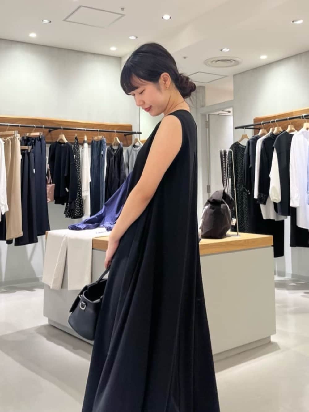 ブラック系のハンドバッグ、ブラック系のワンピースを着用したレディースの春コーディネートの9枚目の写真