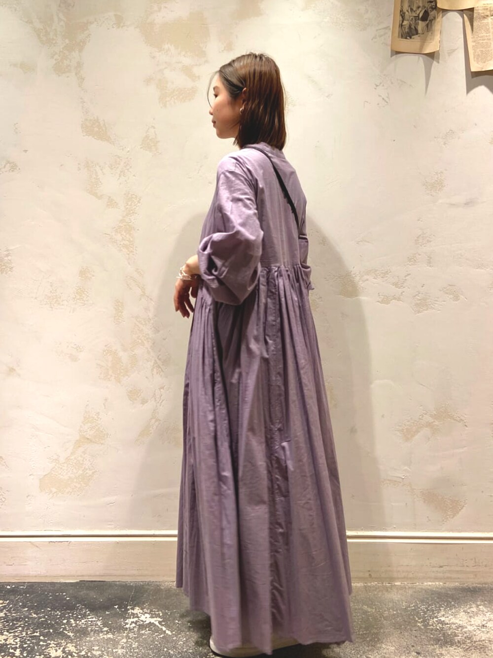 グレー系のワンピース、ブラック系のショルダーバッグ、ホワイト系のスニーカーを着用したレディースの冬コーディネートの3枚目の写真