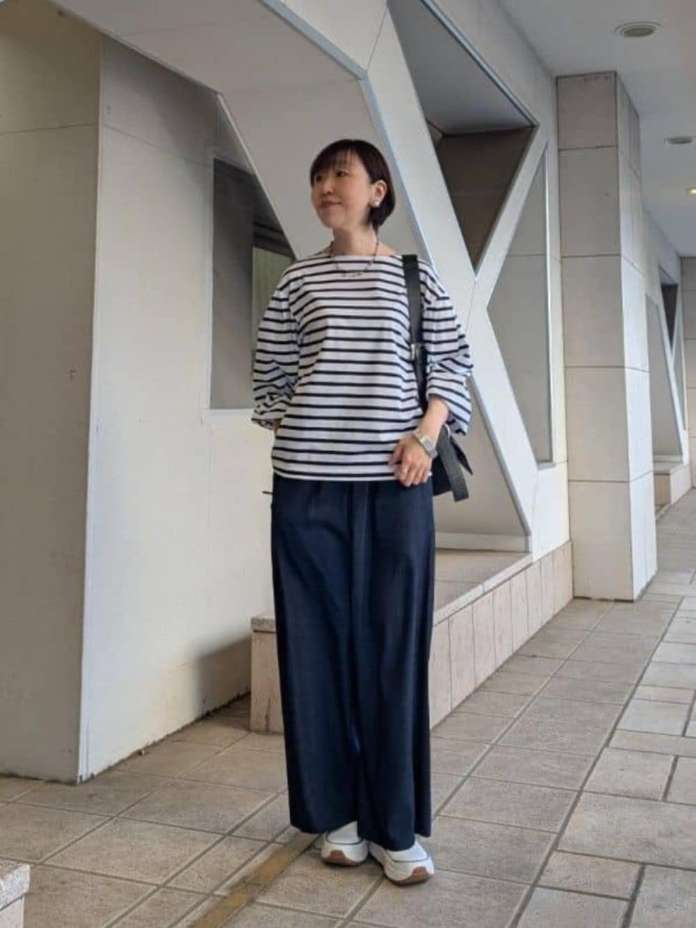 ブルー系のその他パンツ、ホワイト系のTシャツ/カットソー、ホワイト系のスニーカーを着用したレディースの春コーディネートの3枚目の写真