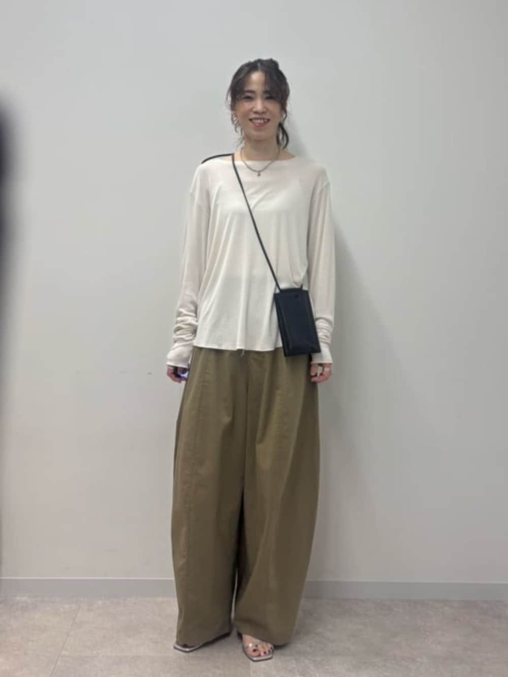 ブラック系のショルダーバッグ、イエロー系のその他パンツ、ホワイト系のTシャツ/カットソーを着用したレディースの春コーディネートの2枚目の写真