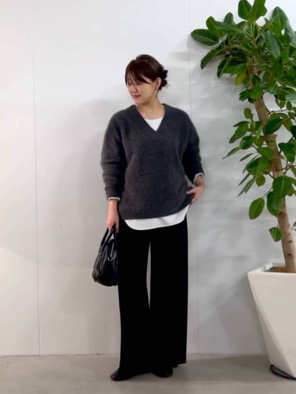 ブラック系のトートバッグ、グレー系のニット/セーター、ホワイト系のシャツ/ブラウスを着用したレディースの秋コーディネートの3枚目の写真