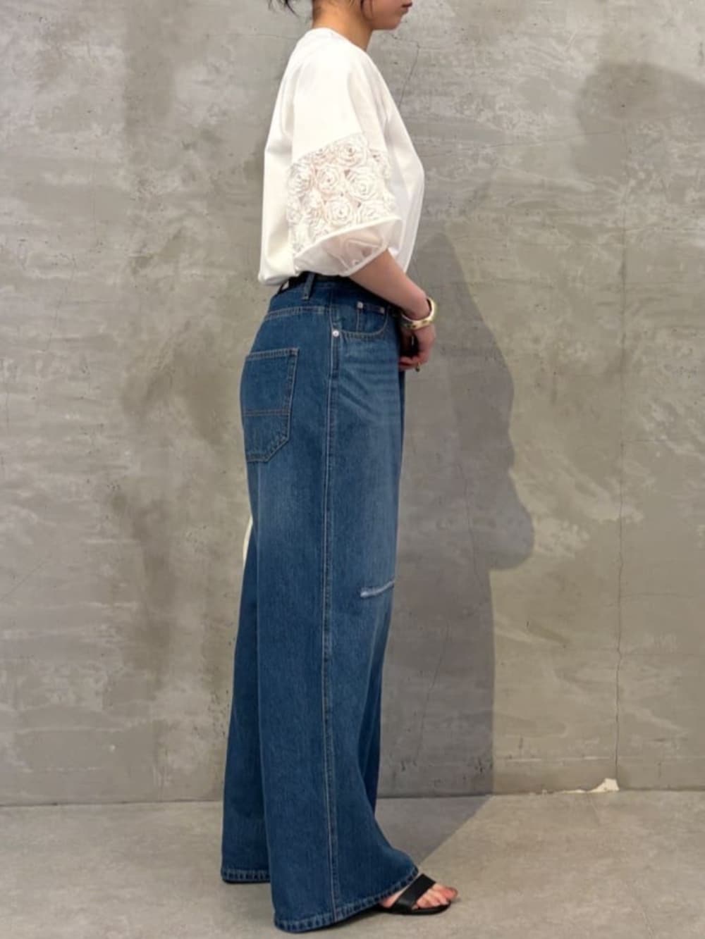 ホワイト系のトートバッグ、ブルー系のその他パンツ、ホワイト系のTシャツ/カットソーを着用したレディースの春コーディネートの3枚目の写真