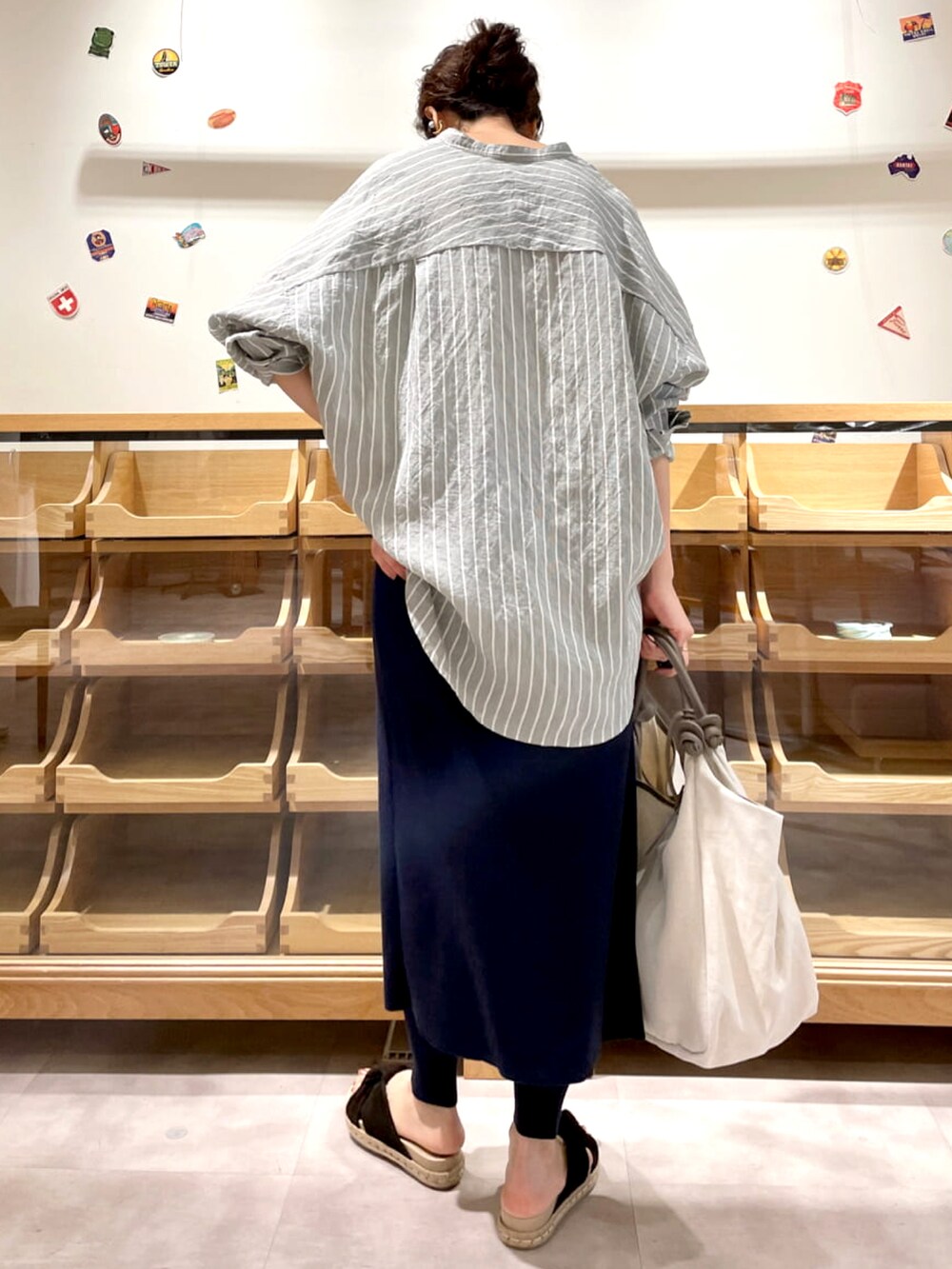 グリーン系のシャツ/ブラウス、ブルー系のその他パンツ、ベージュ系のトートバッグを着用したレディースの春コーディネートの3枚目の写真