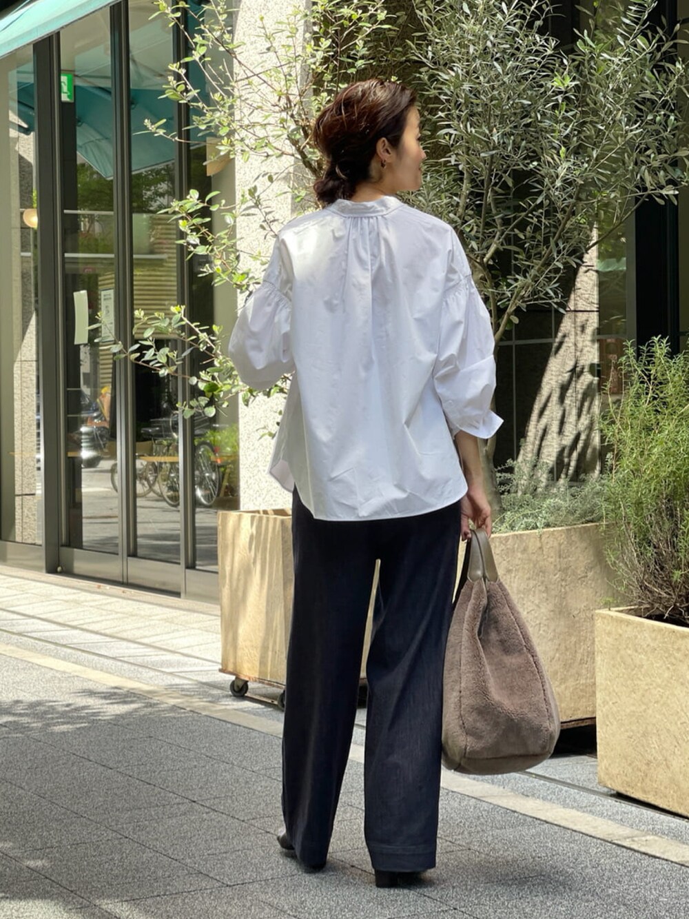 ホワイト系のシャツ/ブラウス、ブルー系のデニムパンツ、ブラウン系のトートバッグを着用したレディースの夏コーディネートの2枚目の写真