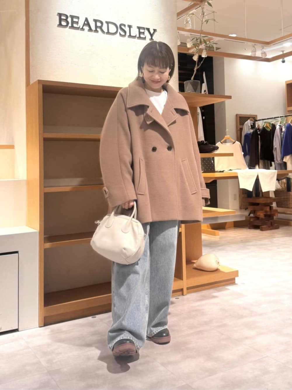 ブルー系のデニムパンツ、イエロー系のその他アウターを着用したレディースの秋コーディネートの4枚目の写真
