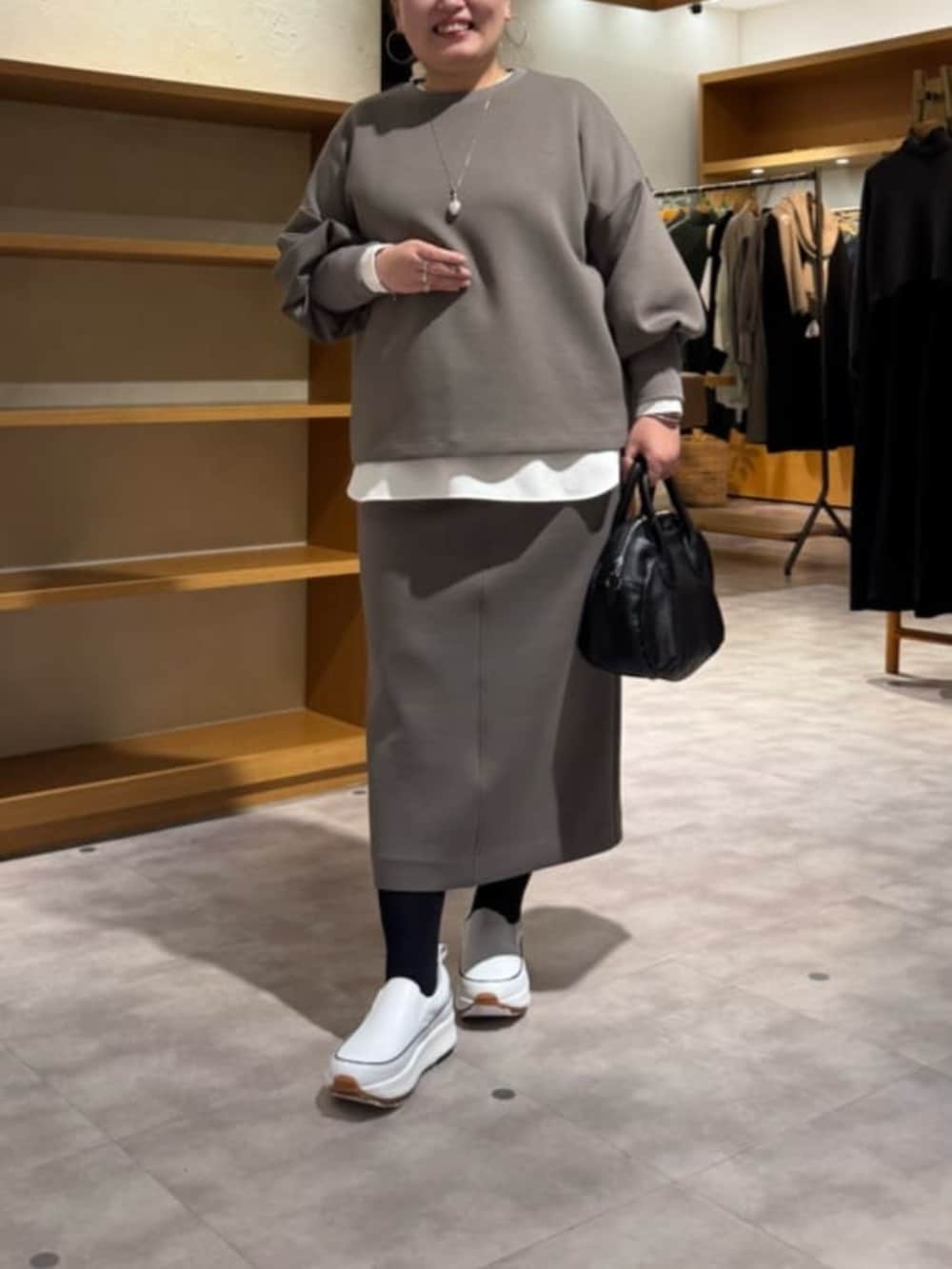 ホワイト系のスニーカー、ブラック系のボストンバッグ、ホワイト系のシャツ/ブラウスを着用したレディースの冬コーディネートの2枚目の写真