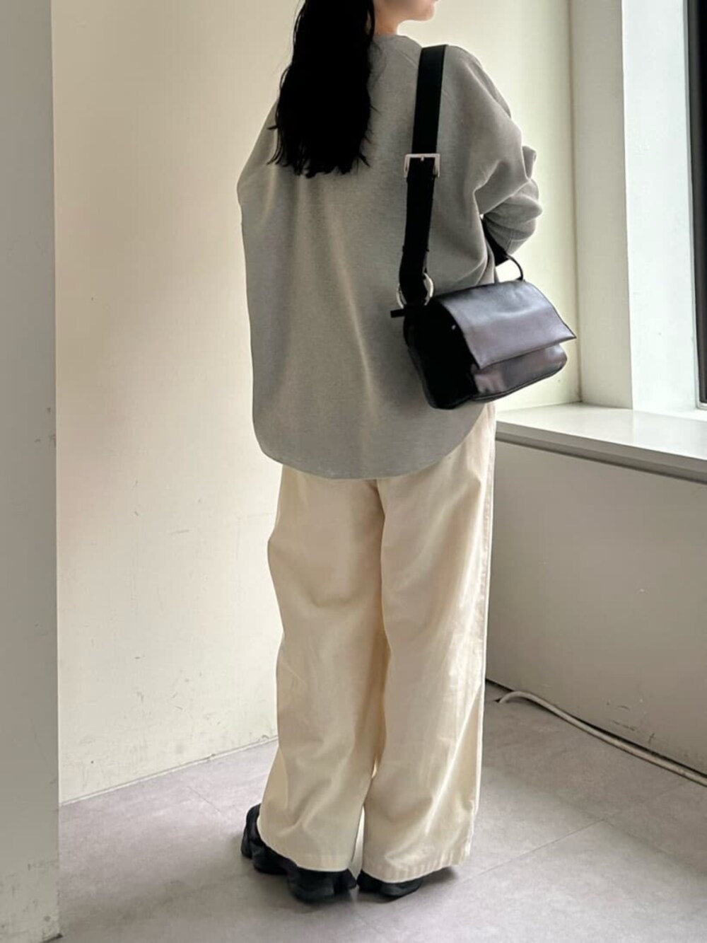 ホワイト系のその他パンツ、ブラック系のショルダーバッグ、グレー系のニット/セーターを着用したレディースの冬コーディネートの2枚目の写真