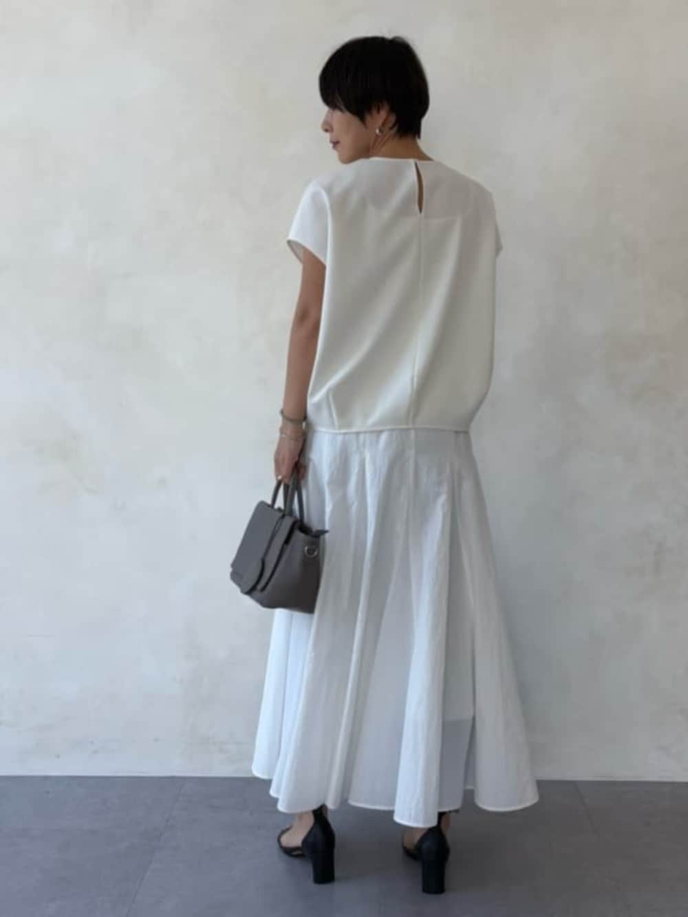 グレー系のハンドバッグ、ホワイト系のスカート、ホワイト系のシャツ/ブラウスを着用したレディースの春コーディネートの3枚目の写真