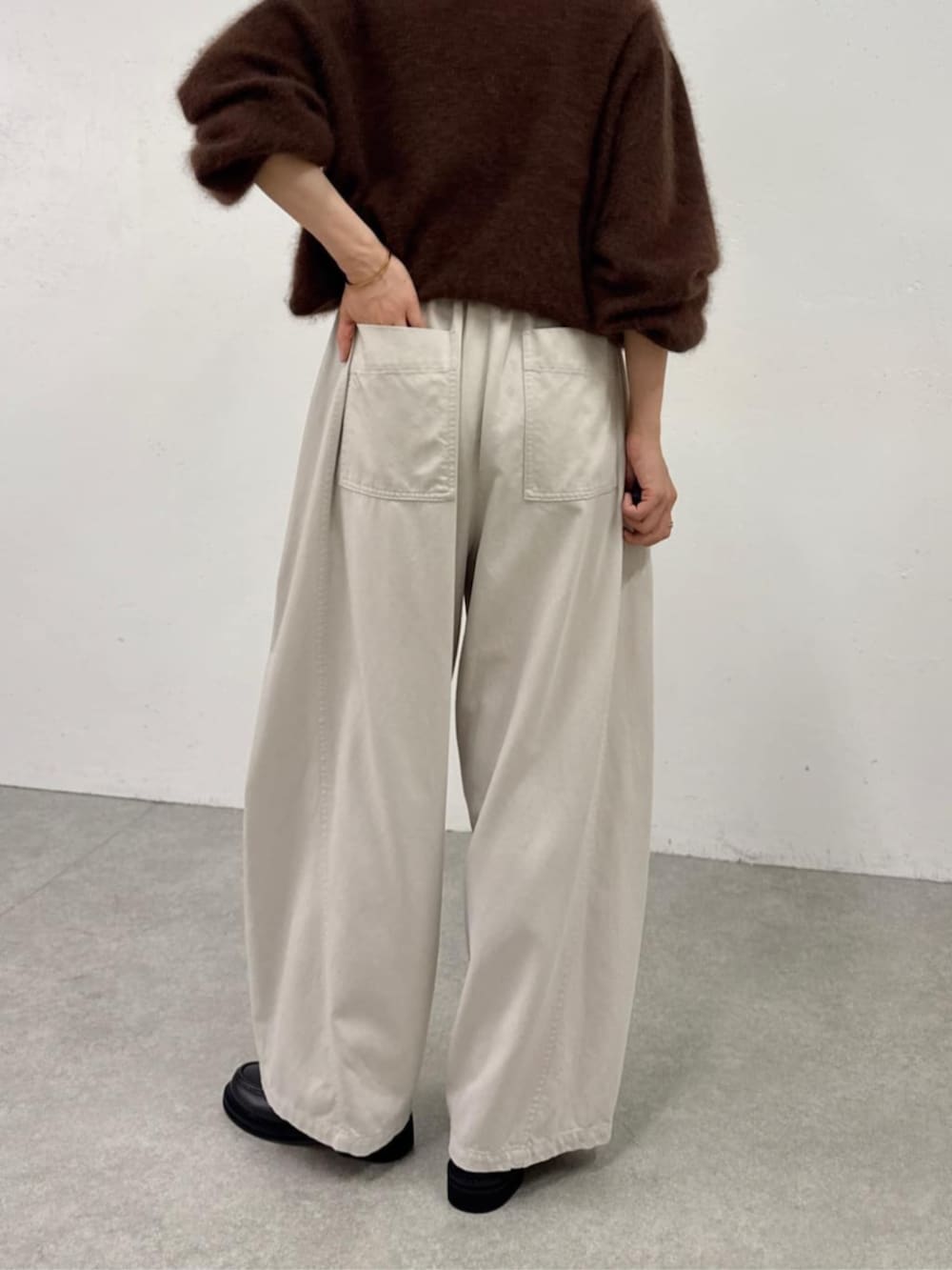 ブラック系のローファー、ホワイト系のその他パンツ、ブラウン系のニット/セーターを着用したレディースの秋コーディネートの7枚目の写真