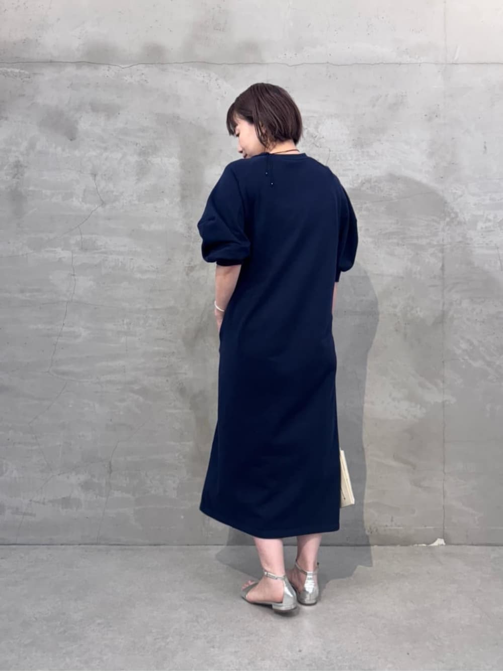 ホワイト系のショルダーバッグ、ブルー系のワンピースを着用したレディースの冬コーディネートの5枚目の写真