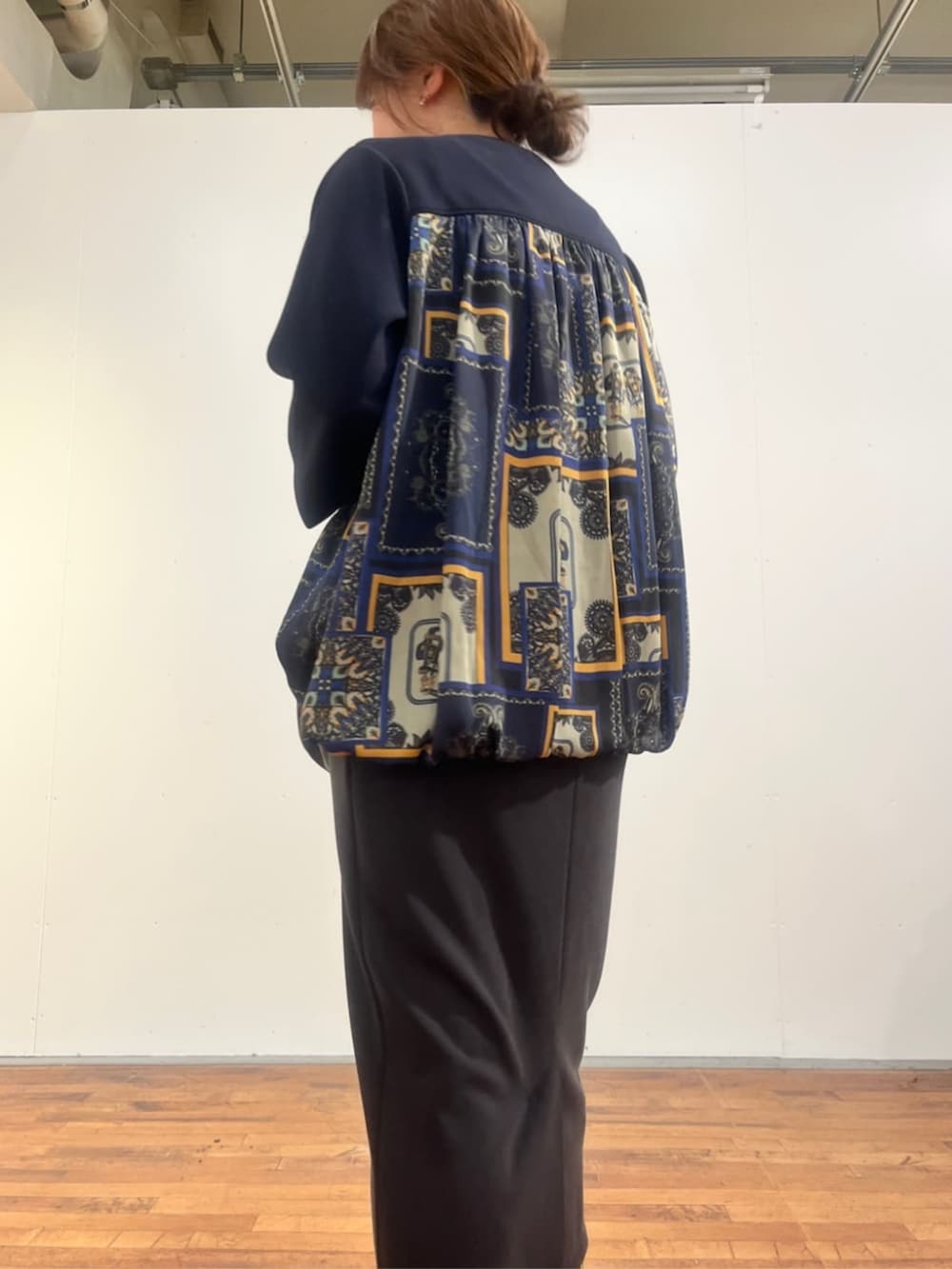 グレー系のスカート、ブラック系のトートバッグ、ブルー系のTシャツ/カットソーを着用したレディースの夏コーディネートの7枚目の写真