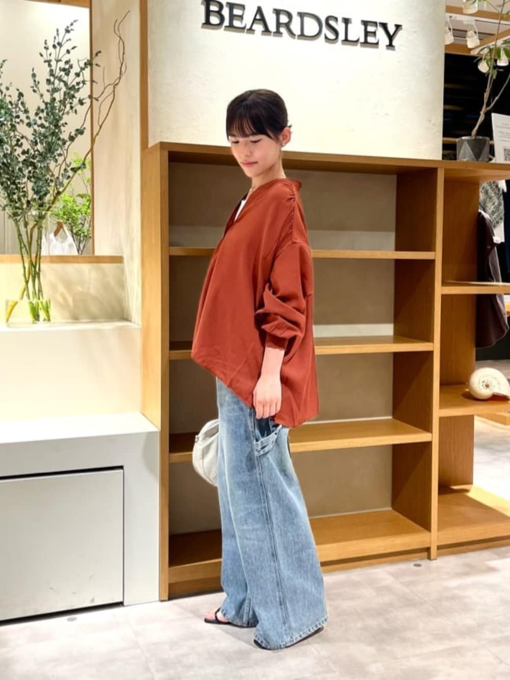 レッド系のシャツ/ブラウス、ブルー系のデニムパンツを着用したレディースの夏コーディネートの2枚目の写真