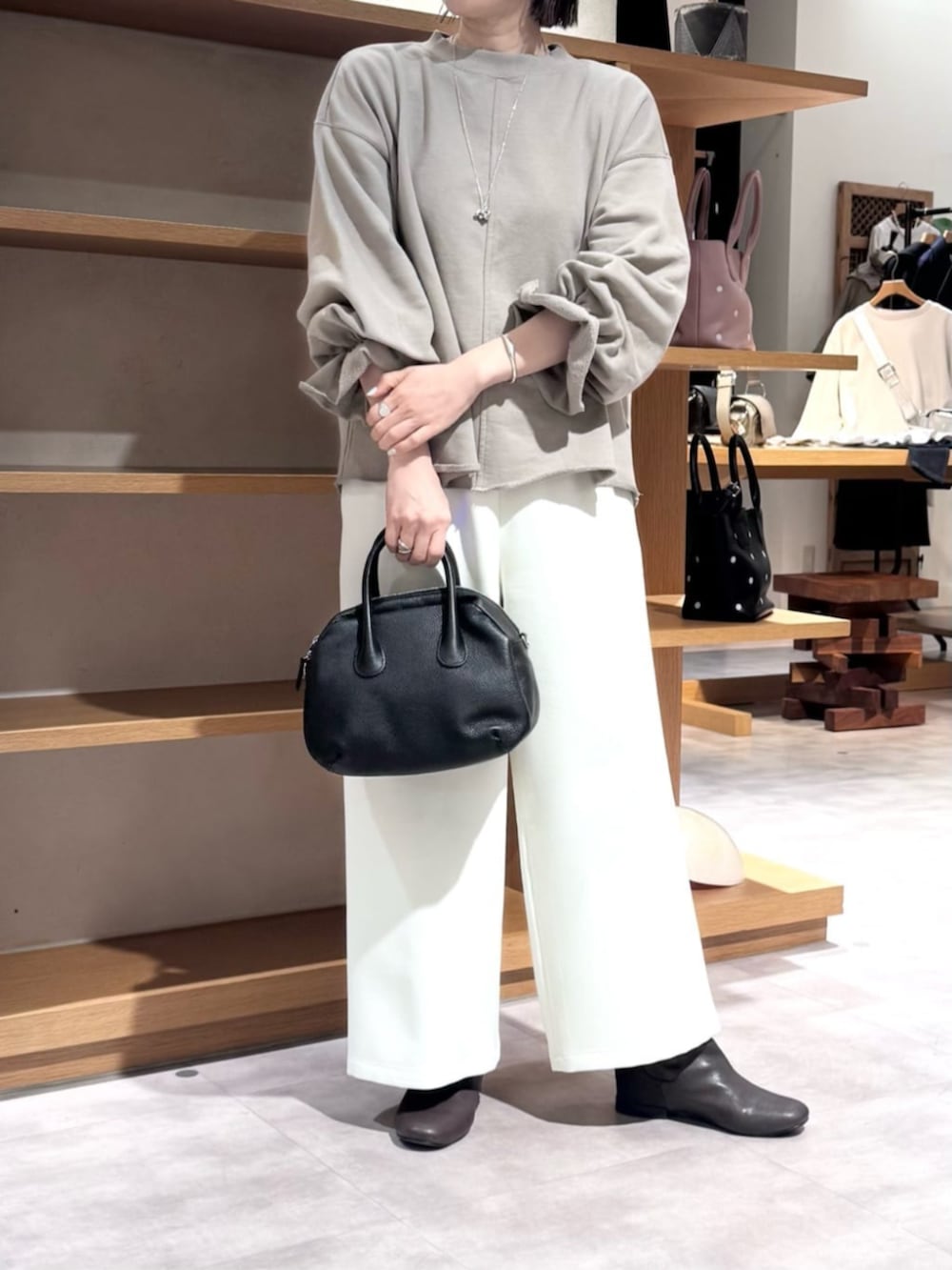 ブラック系のボストンバッグ、ブラウン系のTシャツ/カットソー、ホワイト系のその他パンツを着用したレディースの冬コーディネートの10枚目の写真