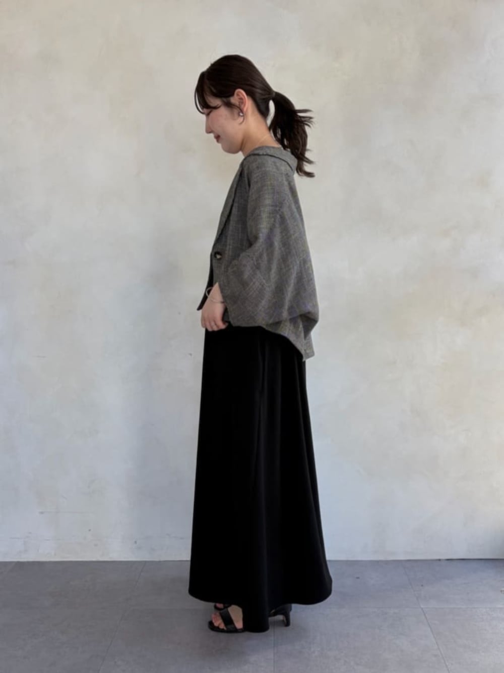 ブラック系のワンピース、ベージュ系のテーラードジャケットを着用したレディースの春コーディネートの2枚目の写真