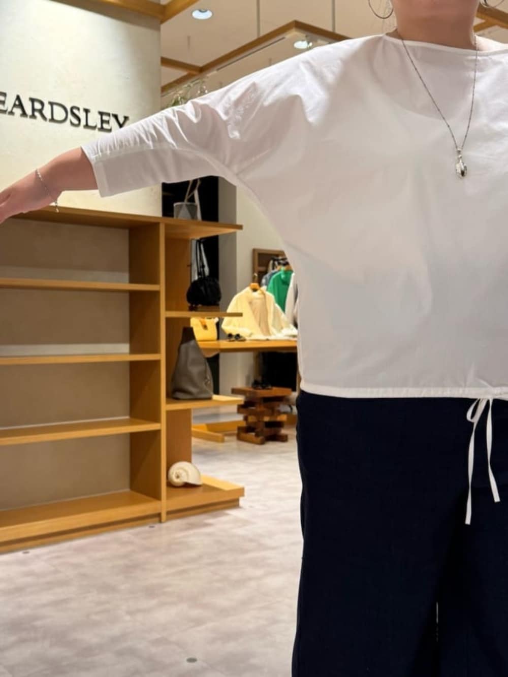 グレー系のボストンバッグ、ブラック系のブーツ、ホワイト系のシャツ/ブラウスを着用したレディースの冬コーディネートの8枚目の写真