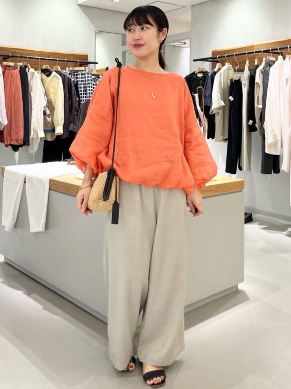 グレー系のその他パンツ、オレンジ系のシャツ/ブラウスを着用したレディースの春コーディネートの2枚目の写真