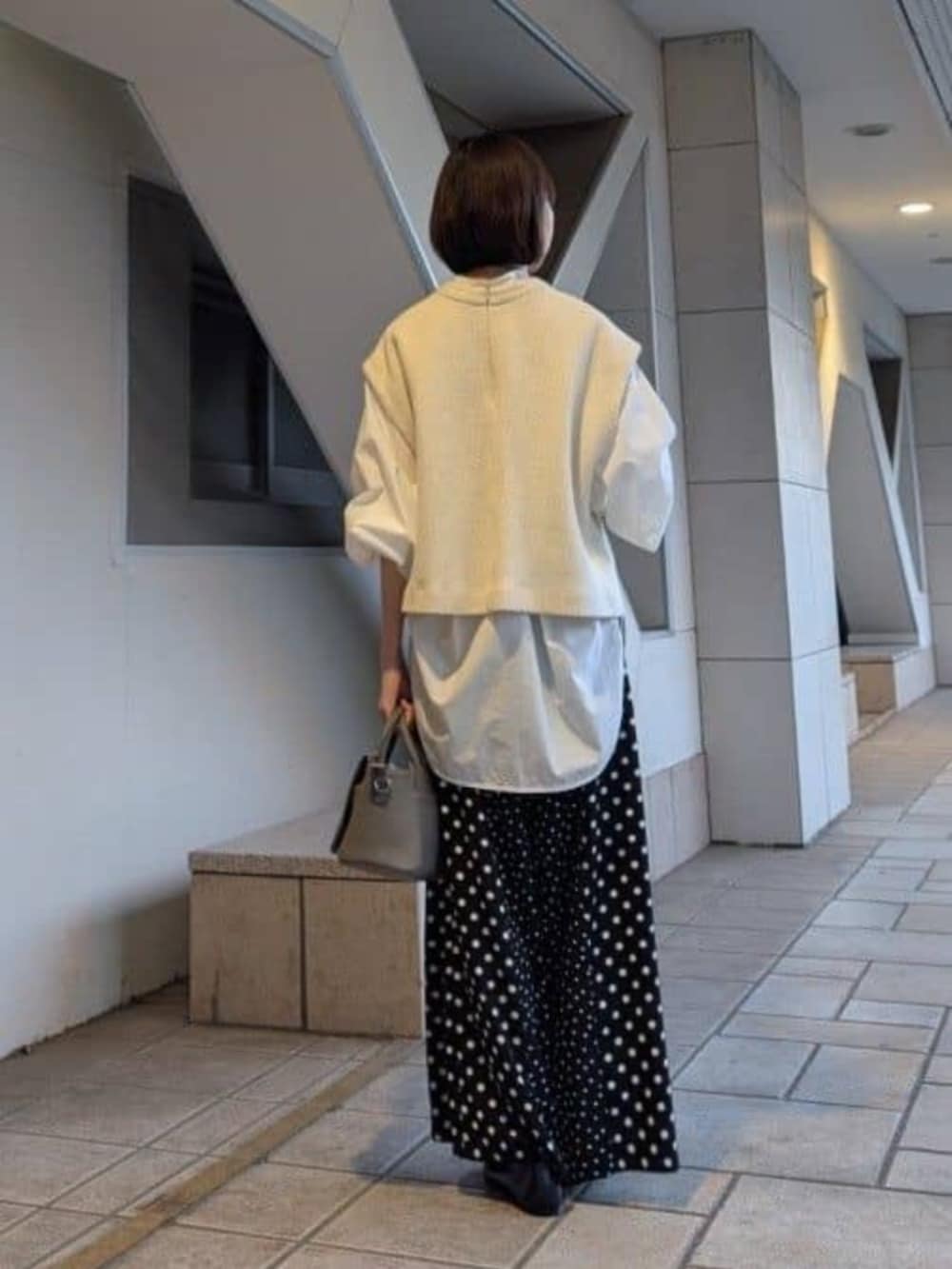 ブラック系のパンプス、ホワイト系のシャツ/ブラウスを着用したレディースの冬コーディネートの2枚目の写真