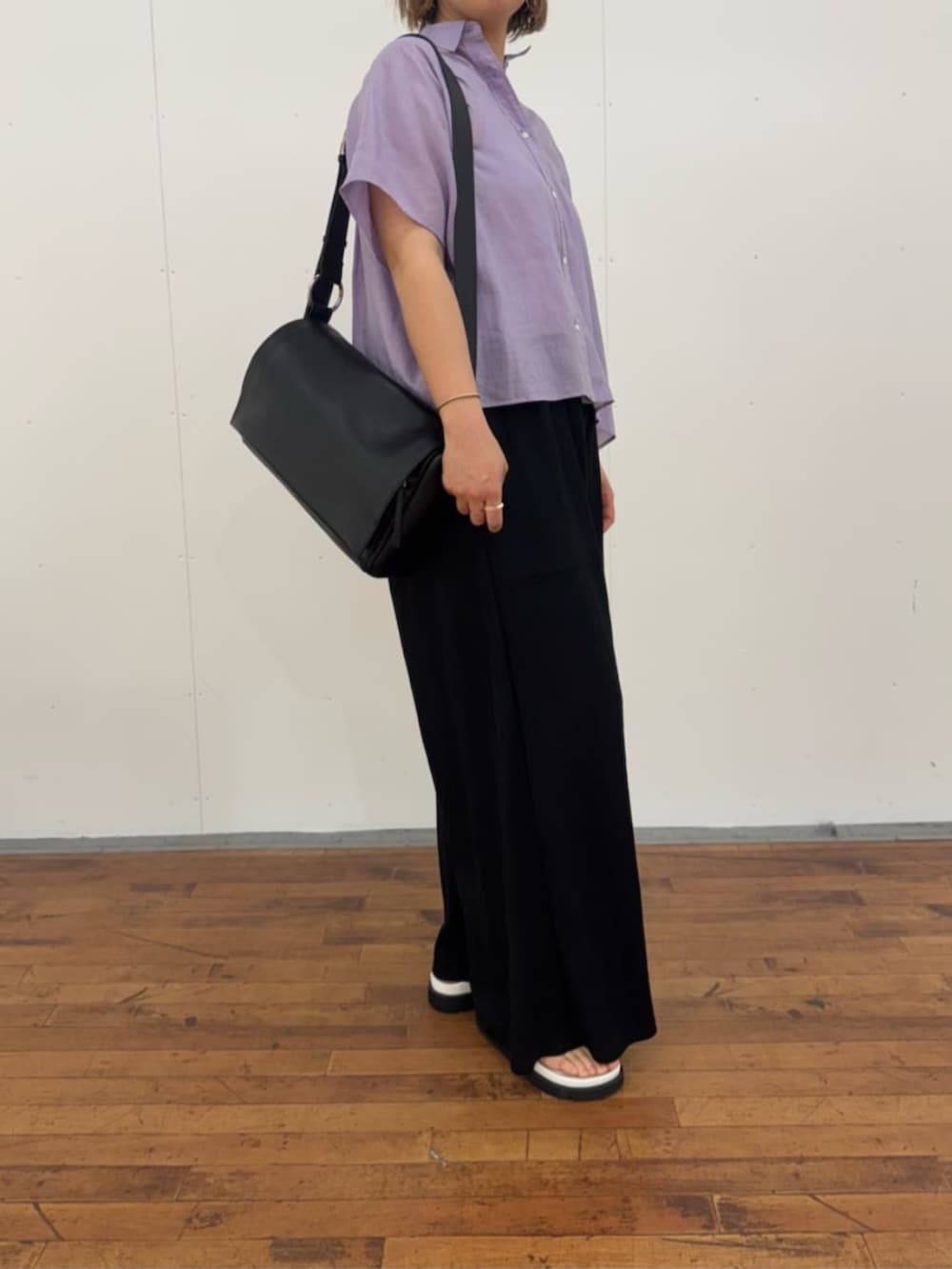 ブラック系のその他パンツ、ホワイト系のサンダル、ブラック系のショルダーバッグを着用したレディースの春コーディネートの6枚目の写真