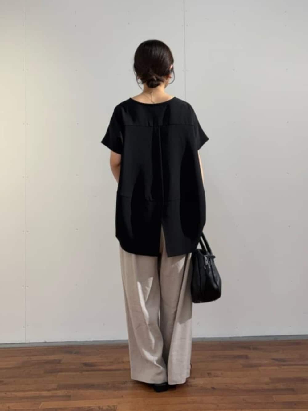 ブラック系のボストンバッグ、ブラック系のシャツ/ブラウス、グレー系のその他パンツを着用したレディースの春コーディネートの7枚目の写真