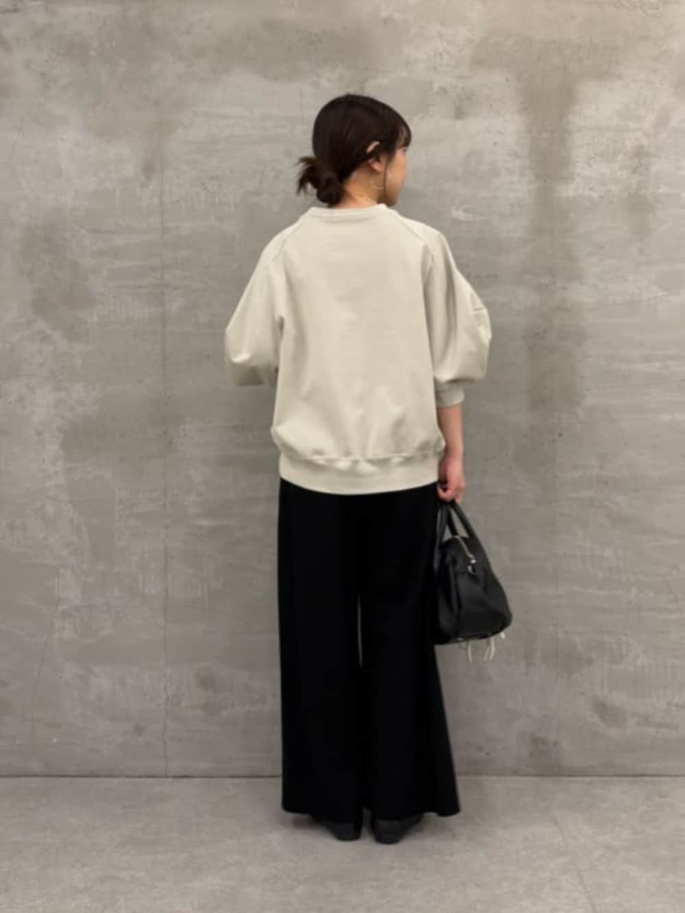 ブラック系のボストンバッグ、ブラック系のその他パンツ、グレー系のTシャツ/カットソーを着用したレディースの冬コーディネートの7枚目の写真