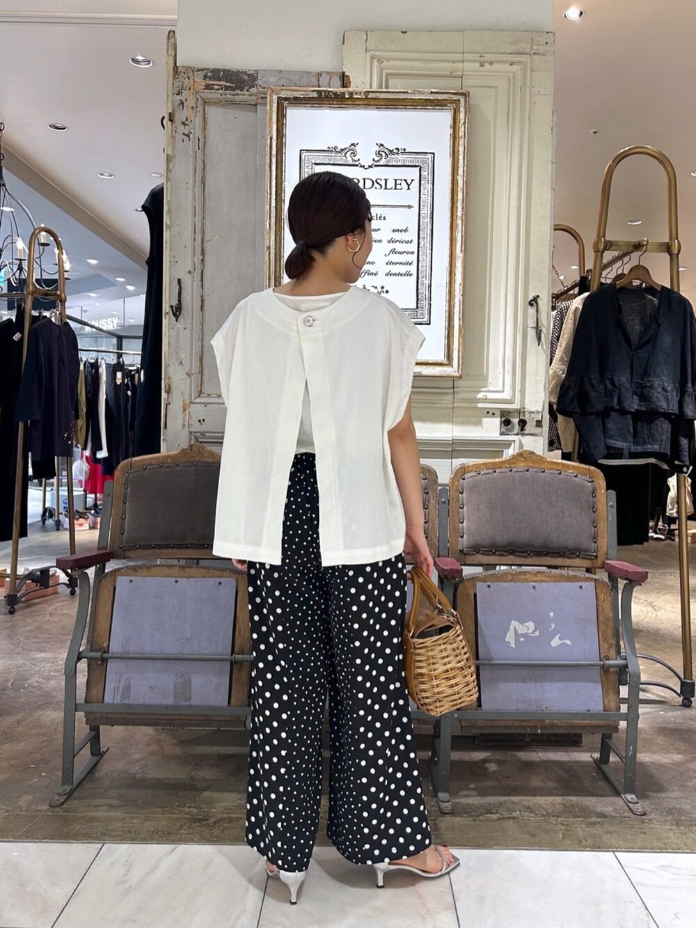 ホワイト系のベスト、ブラック系のその他パンツを着用したレディースの夏コーディネートの3枚目の写真