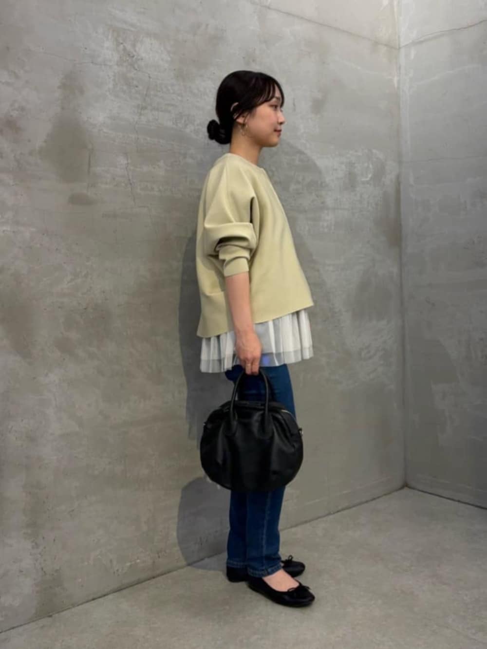 ホワイト系のキャミソール、ブルー系のデニムパンツ、ベージュ系のカーディガン/ボレロを着用したレディースの秋コーディネートの5枚目の写真