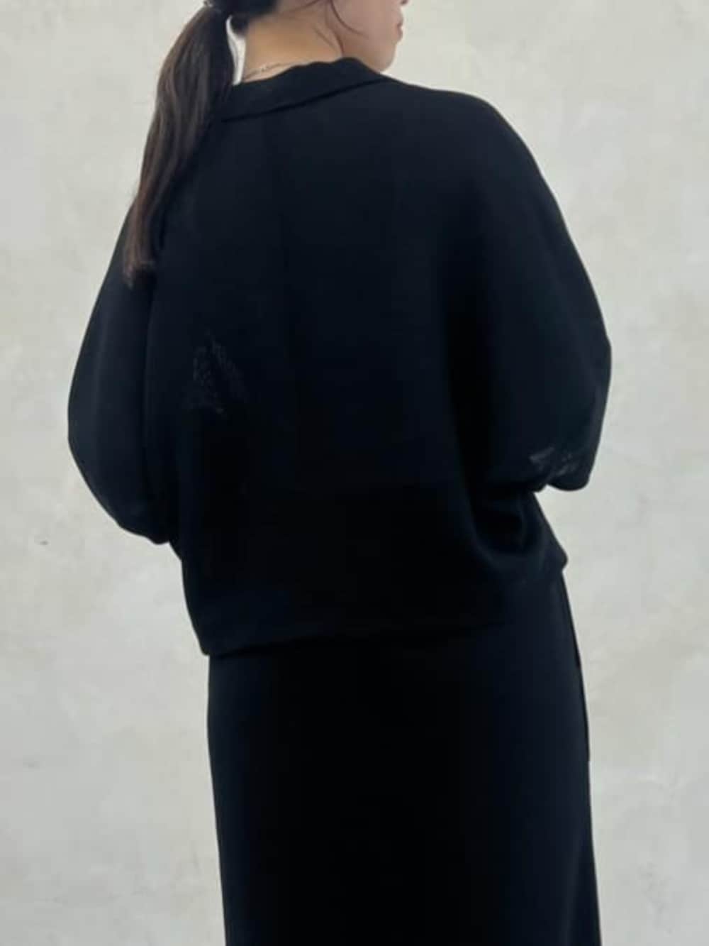 グレー系のハンドバッグ、ブラック系のテーラードジャケット、ブラック系のスカートを着用したレディースの春コーディネートの8枚目の写真