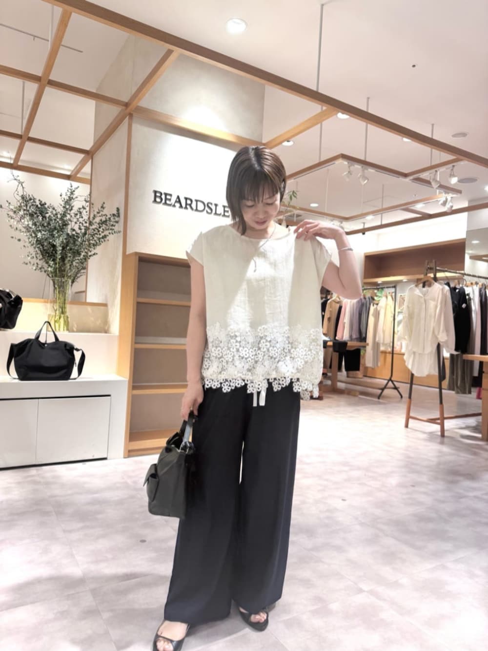 ブルー系のその他パンツ、ブラック系のトートバッグ、ホワイト系のシャツ/ブラウスを着用したレディースの春コーディネートの6枚目の写真