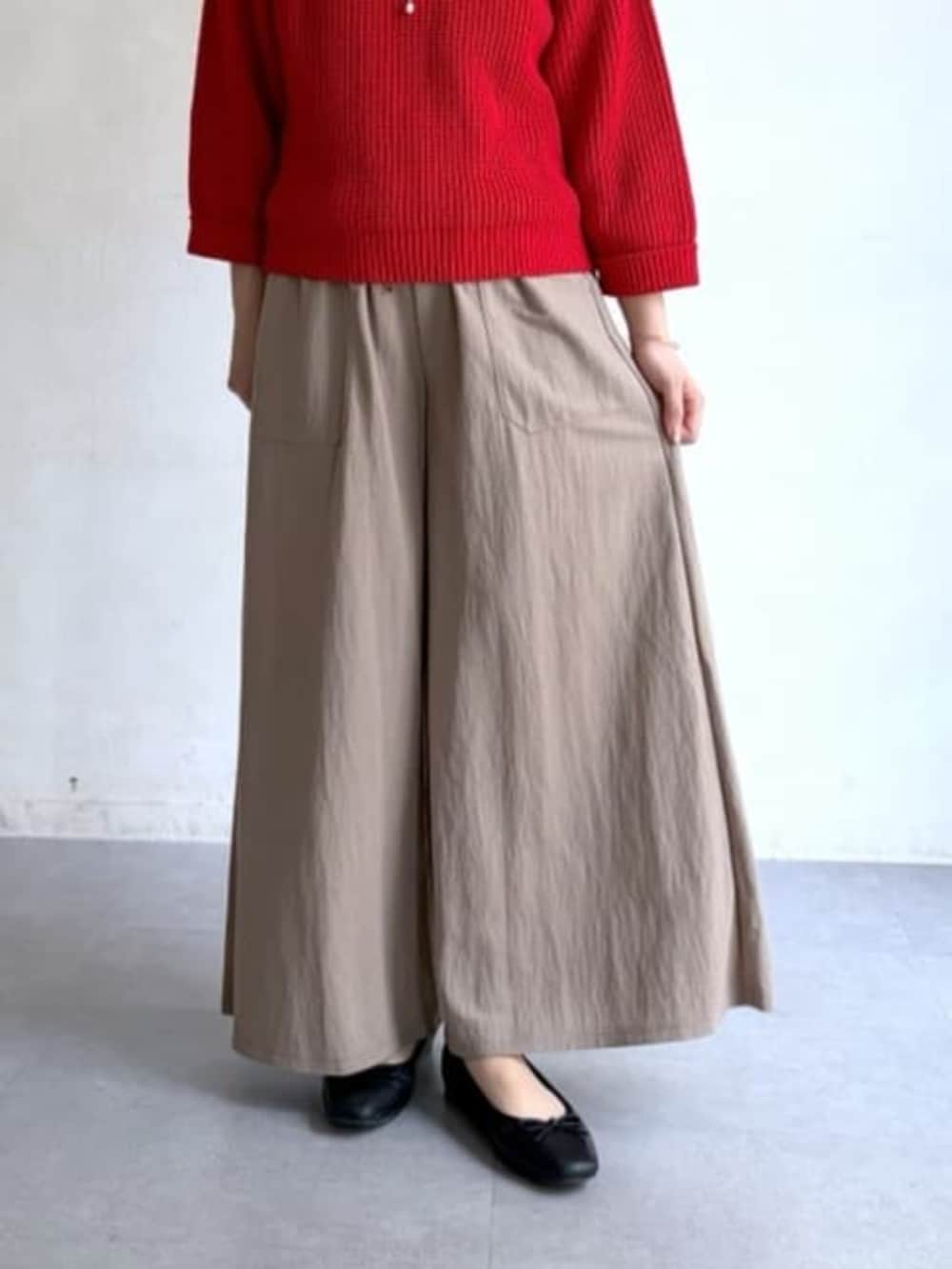 ベージュ系のその他パンツ、レッド系のニット/セーターを着用したレディースの冬コーディネートの6枚目の写真