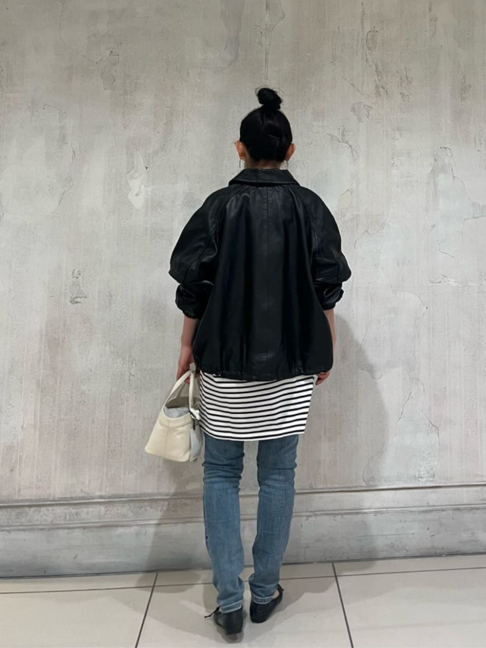 ブルー系のデニムパンツ、ブラック系のブルゾンを着用したレディースの冬コーディネートの6枚目の写真