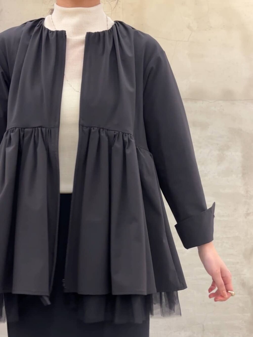 ブラック系のスカート、ブラック系のブルゾンを着用したレディースの冬コーディネートの6枚目の写真