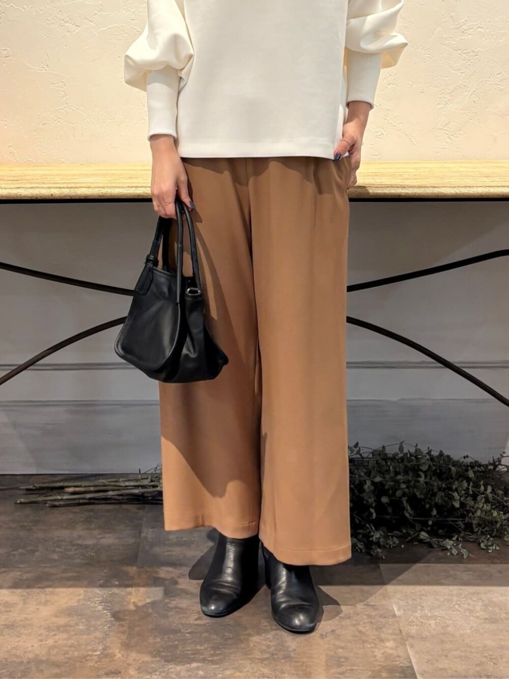 イエロー系のその他パンツ、ブラック系のトートバッグ、ホワイト系のTシャツ/カットソーを着用したレディースの冬コーディネートの9枚目の写真