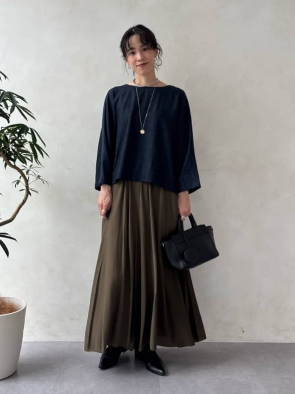 ブラック系のハンドバッグ、ブルー系のシャツ/ブラウス、グリーン系のその他パンツを着用したレディースの夏コーディネートの6枚目の写真