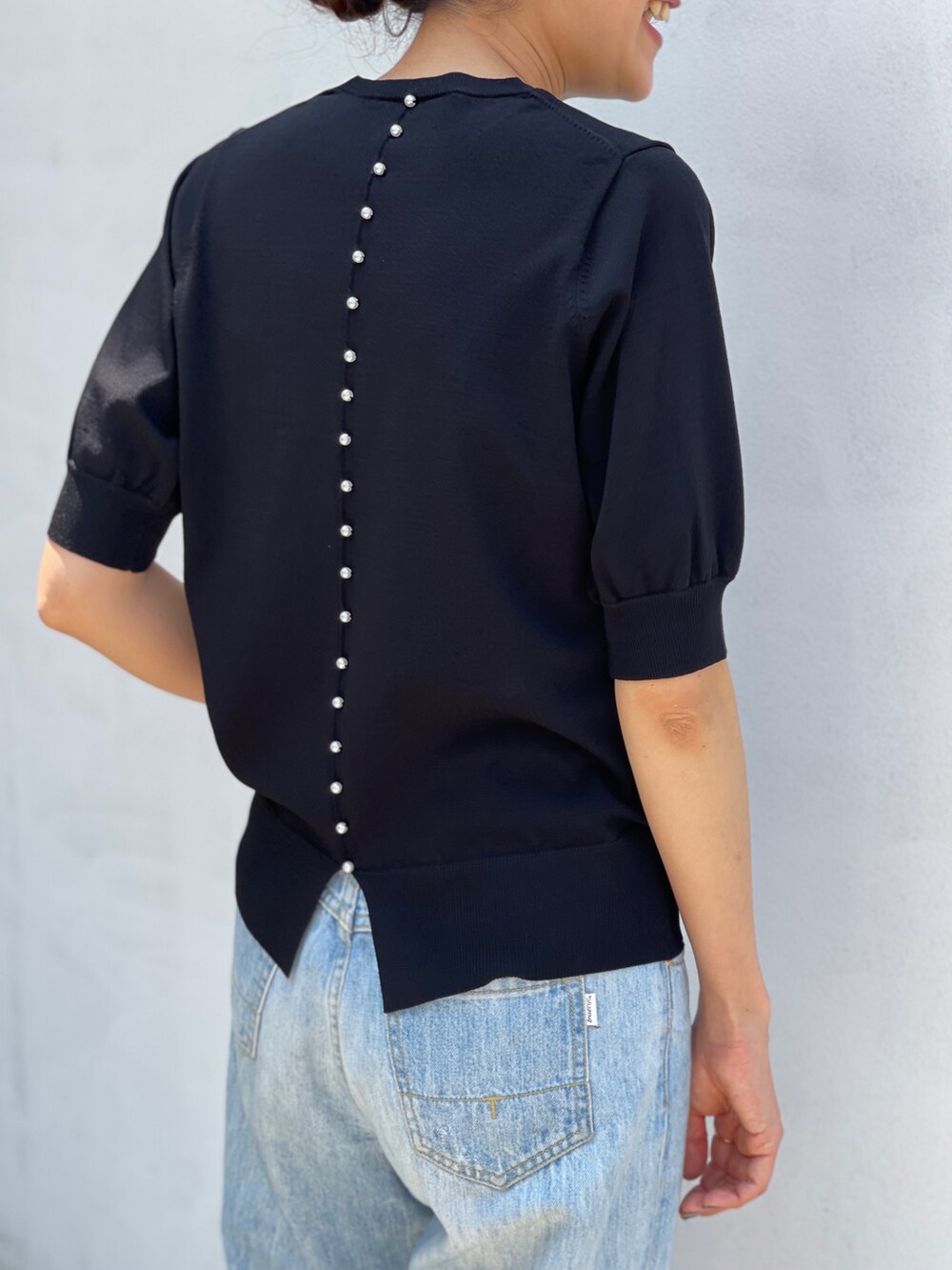 ブラック系のニット/セーターを着用したレディースの夏コーディネートの2枚目の写真